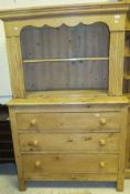 A pine dresser, the plate rack over three graduated drawers with turned knob handles