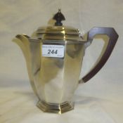 A silver water jug of tapering faceted form (by Adie Bros. Ltd., Birmingham 1937)