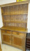 A 19th century pine dresser, the two shelf closed back over a moulded cornice to a rectangular top