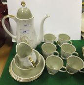 A Susie Cooper bone china coffee set for six place settings, decorated in pale green and white