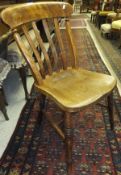 A dark elm stick back kitchen chair by Ercol and two further stick back elm seated kitchen chairs