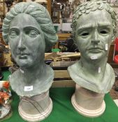 Two bronze effect heads of neo-classical form with a verdigris finish, each on cylindrical white