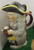 A 19th Century Staffordshire pottery Toby jug, modelled seated on a chair holding a jug of ale and a