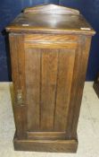 A late 19th century stained oak pot cupboard with single panelled door on plinth base