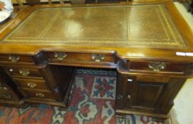 A reproduction mahogany partner's desk, the shaped top with tooled and gilded leather insert above a