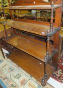 A Victorian oak four tier open waterfall bookcase with a shaped top rail