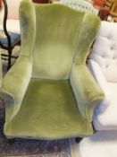 A late Victorian upholstered wing back scroll arm chair on turned and ringed front legs