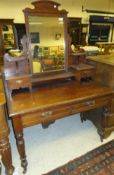 A late 19th Century walnut mirror backed dressing table, the rectangular swing plate flanked by