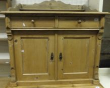 A Victorian pine wash stand, the raised back over two frieze drawers and a pair of panelled doors