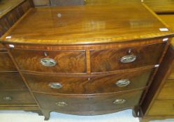 An early 19th Century mahogany and satinwood banded bow fronted chest of two short and two long