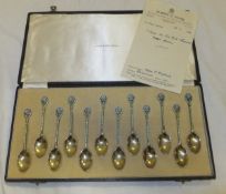 A set of twelve silver gilt and enamel decorated coffee spoons with floral finials by Turner &