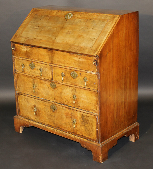 An 18th Century walnut bureau, the fall front opening to reveal well, various drawers and pigeon