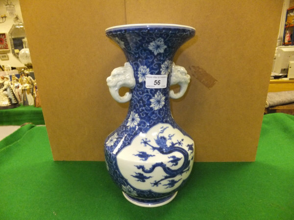 A Chinese porcelain twin-handled vase decorated with dragon and cloud motifs and figural handles