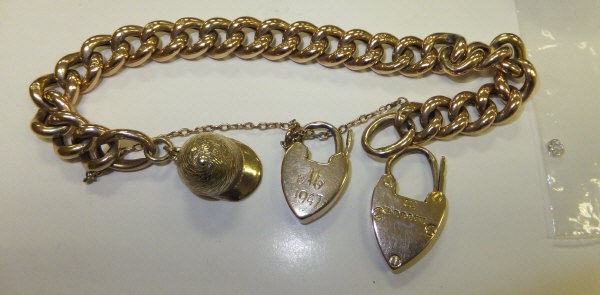A 9 carat gold bracelet with two heart shaped locks, a 9 carat gold charm in the form of a jockey'