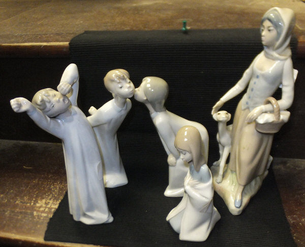 A collection of Lladro figures to include "Child in nightshirt yawning", "Young girl kneeling", "Boy