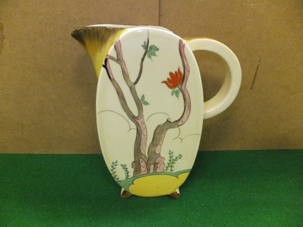 A Clarice Cliff Wilkinson Limited "Bon jour" jug of oval form decorated with tree in a hilly