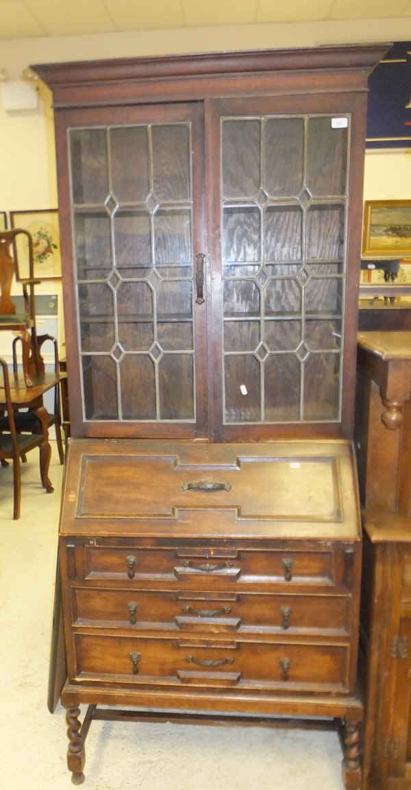 An early 20th century oak bureau bookcase with leaded glazed doors