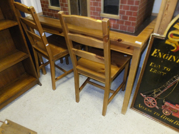 An Ikea pine kitchen table and four ladder back chairs