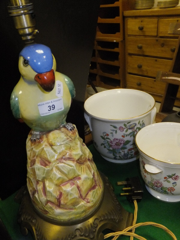 A glazed polychrome decorated pottery table lamp as a parrot seated upon a rock with acanthus