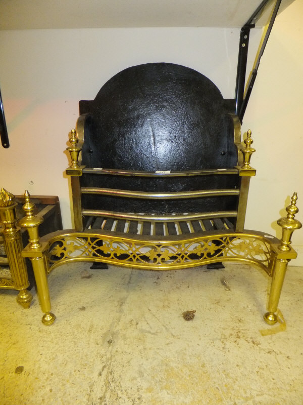 A Regency style brass, steel and iron fire basket with serpentine front and integral dogs
