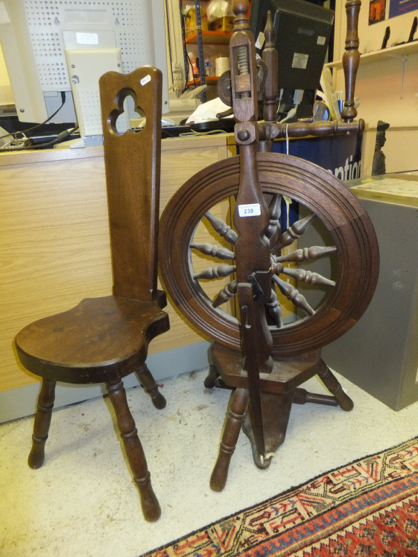 A dark stained modern spinning wheel and stool