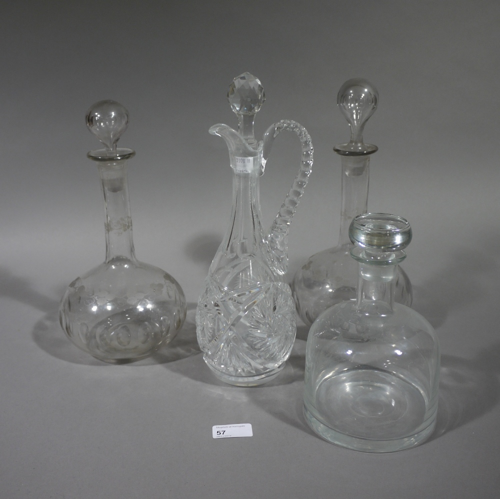 A pair of vine etched decanters with hollow stoppers, a cut glass ewer and faceted stopper and a