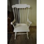 A white painted rail back rocking chair