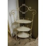 A cream metal three tier etagere with sc