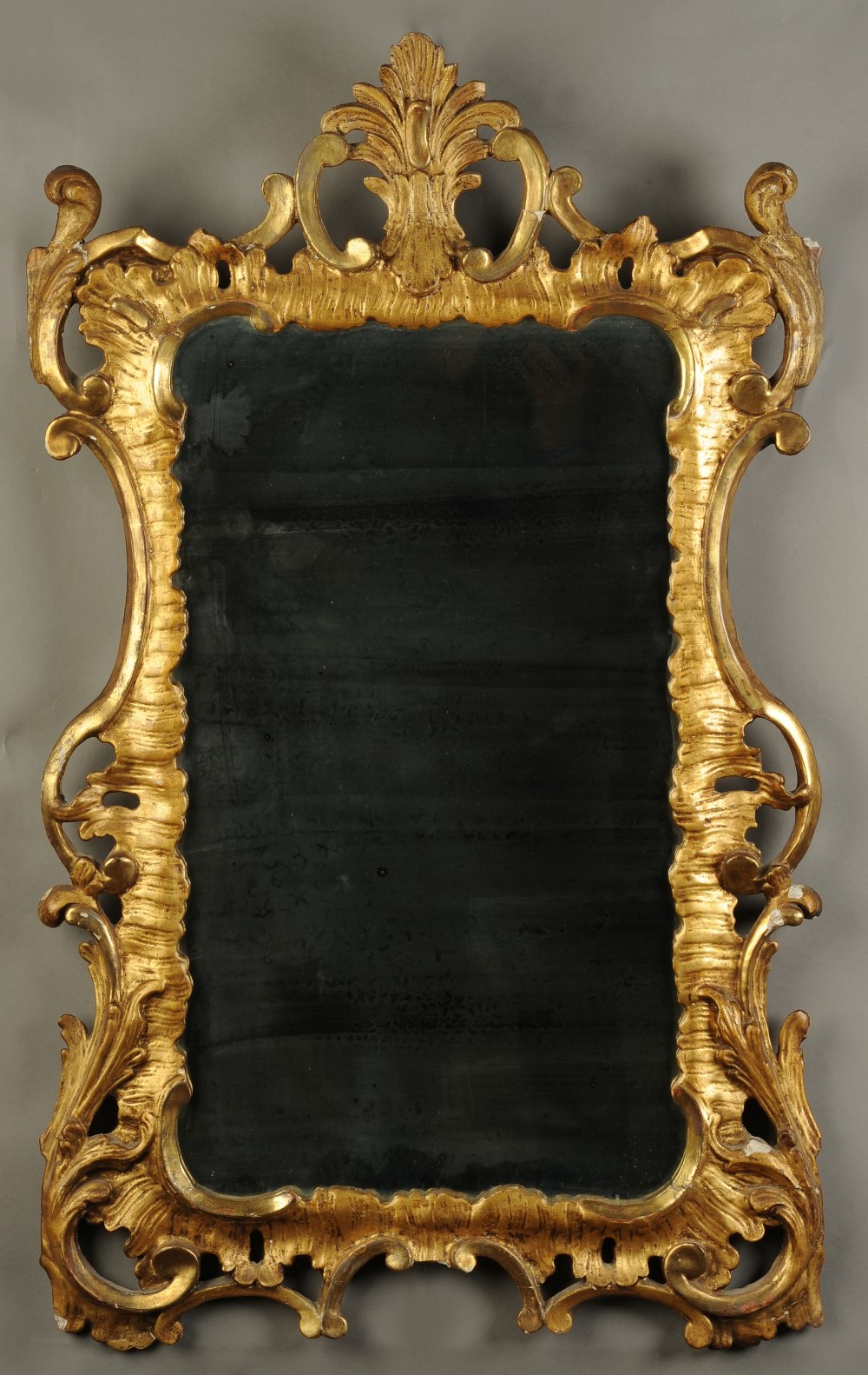 A GEORGE III GILTWOOD WALL MIRROR, rectangular, having a later plate, within rocaille and 'c' scroll