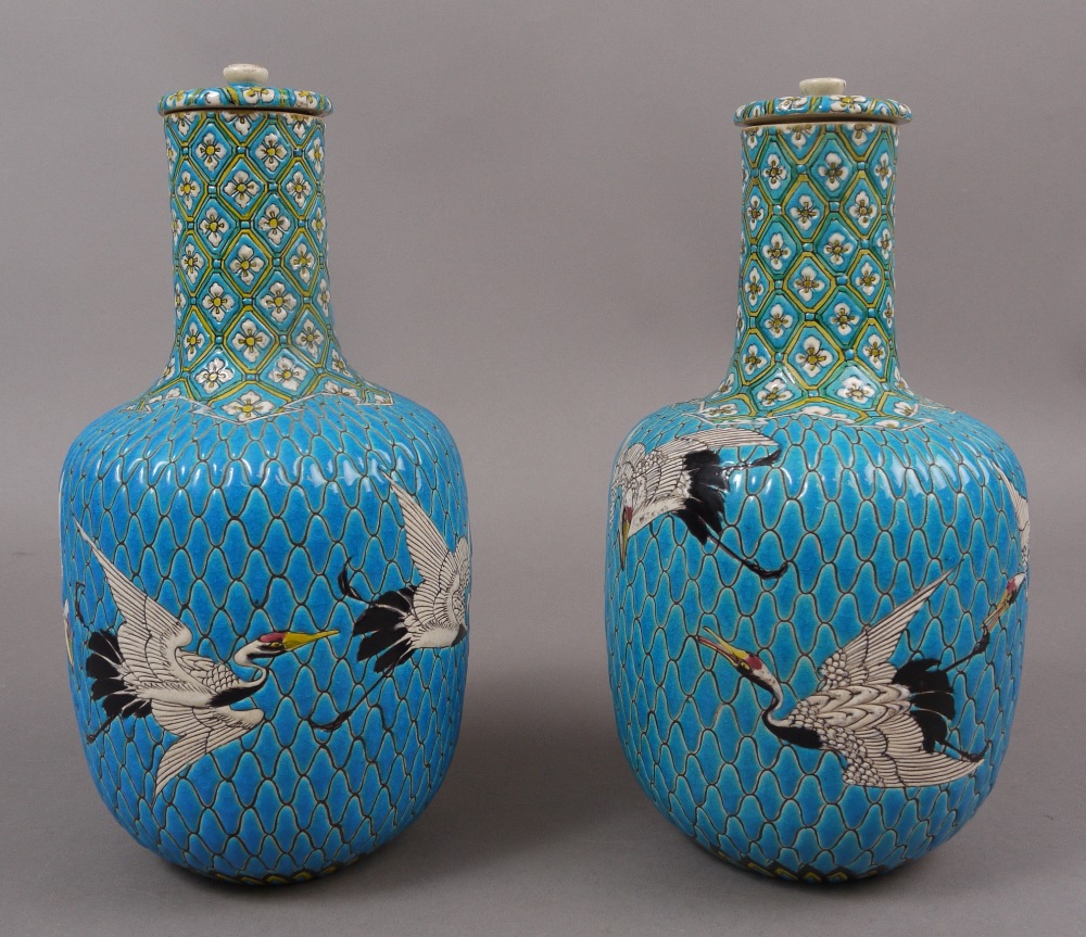 A PAIR OF JAPANESE TURQUOISE GROUND POTTERY VASES AND COVERS, MEIJI, each ovoid body enamelled in