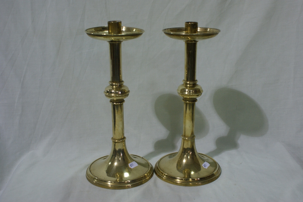 A Pair Of Circular Based Brass Candle Sticks With Drip Trays