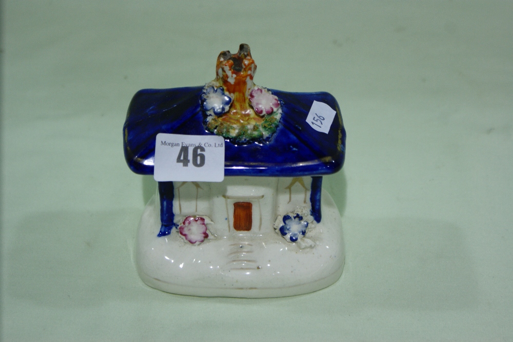 A Staffordshire Pottery Money Box Modelled As A Cottage