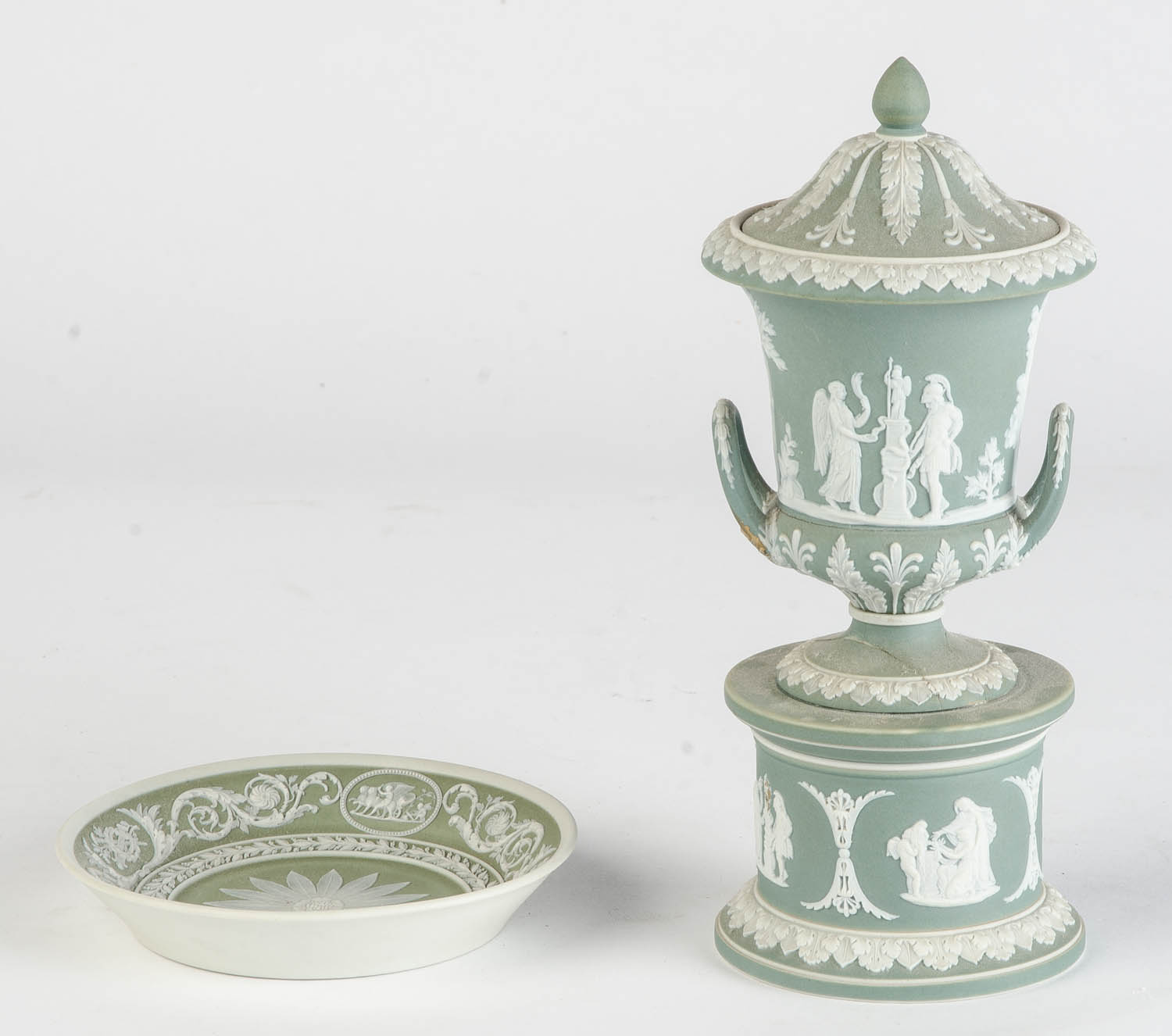 Two Wedgwood green jasper cups and saucers and a covered urn on stand, English, 19th century the