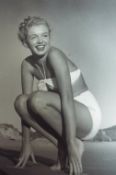 Marilyn Monroe original bw photograph showing Marilyn in swimsuit crouching down and smiling on