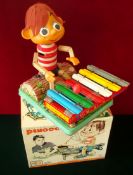 Rosko Toys 1963 Battery Operated Pinocchio Playing Xylophone: Plastic headed figure sitting on a tin