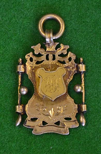 1896 silver gilt decorative golf medal – mounted with golf clubs, balls and raised shield engraved