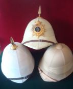 Three Pith Helmets: To consist of two spiked examples one having Royal Warwickshire Regt Helmet