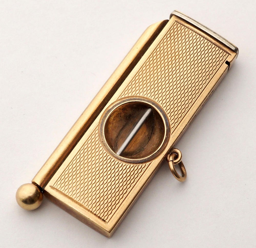 VINTAGE NINE CARAT GOLD CIGAR CUTTER
with engine turned decoration and ring attachment, 5.6cm x 2cm,