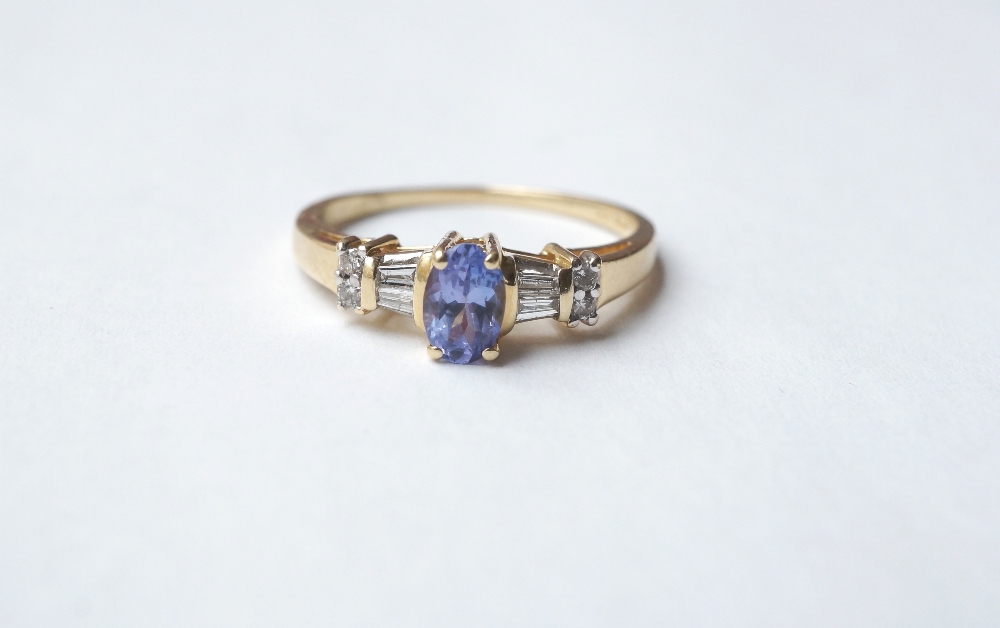 TANZANITE AND DIAMOND RING
the central oval cut tanzanite flanked by baguette and round cut