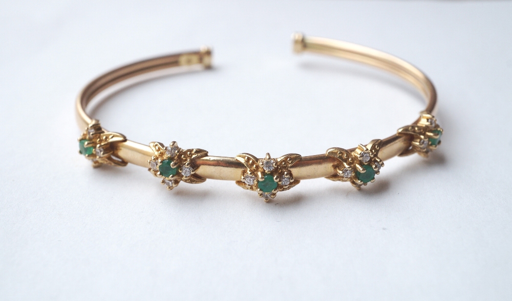 ATTRACTIVE EMERALD AND GEM SET BANGLE 
the nine carat gold bangle set with five emerald and clear