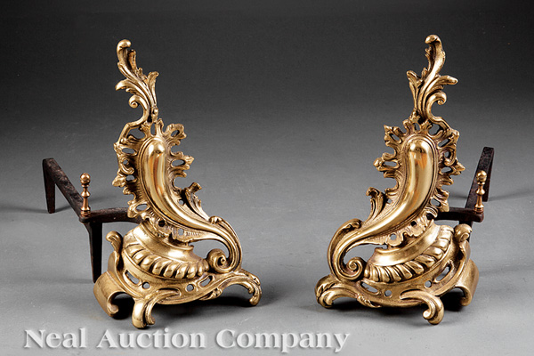 A Pair of Louis XV-Style Gilt Bronze Chenets, with elaborate scrolling Rococo form, turned log stop,