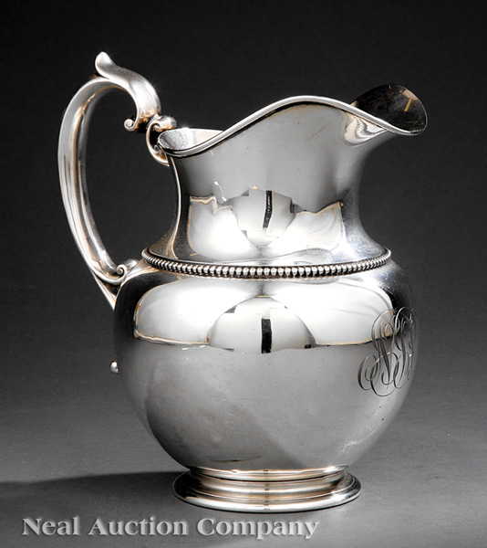 An American Sterling Silver Water Pitcher, squat form with scroll handles, beaded border and