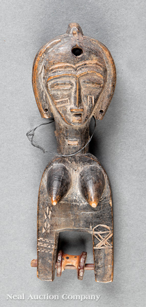 An African Carved Wood Weaving Pulley, Ivory Coast, carved in the form of a female nude, height 6