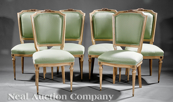 A Set of Six Louis XVI-Style Carved and Crème Peinte Side Chairs, shaped floral crests, molded