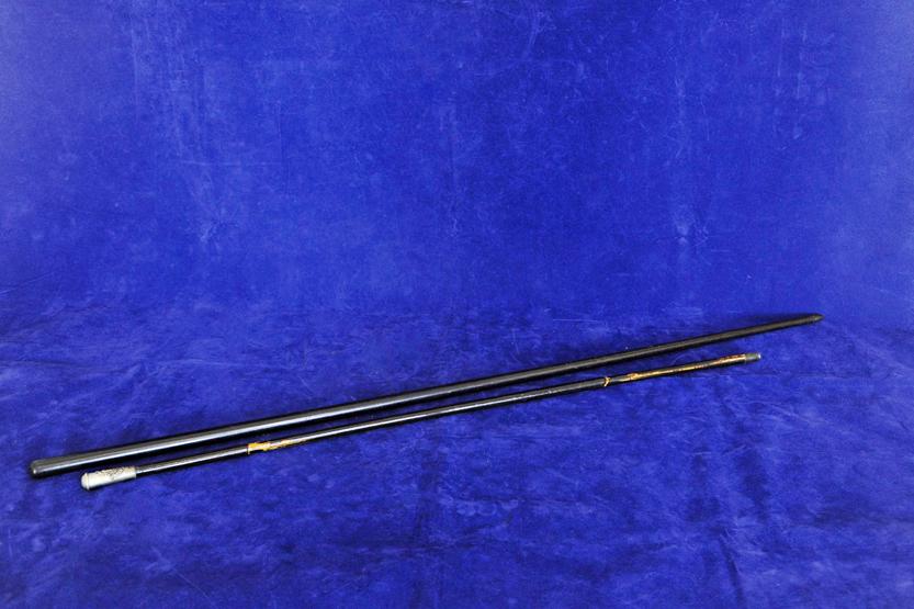 A regimental swagger stick with white metal cap. 27ins and a turned ebony ditto. 33¼ins.