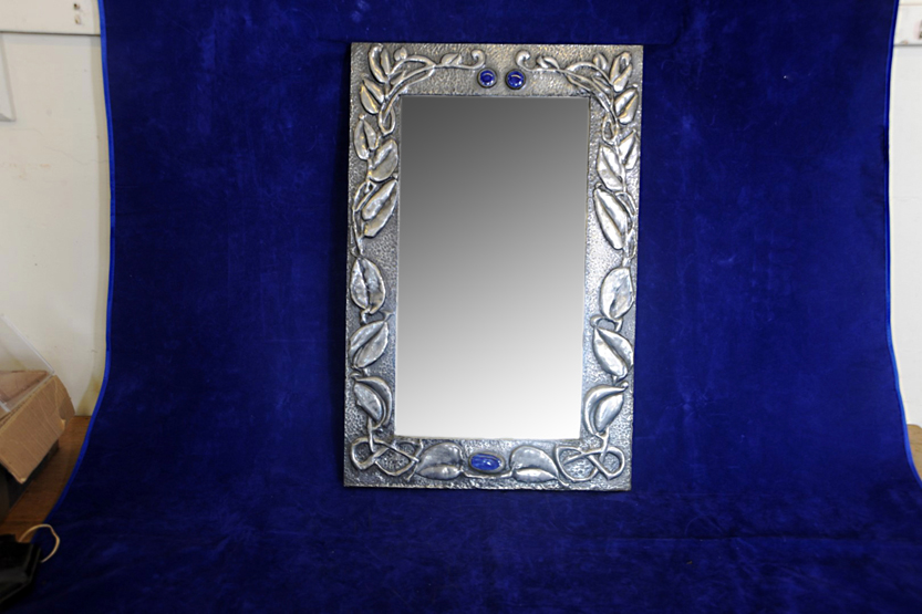 An early 20th century pewter framed bevelled wall mirror, the frame with embossed stylised leaf