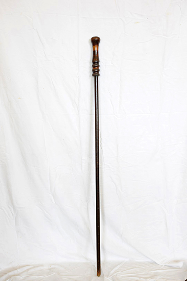 A staff with turned wooden handle and turned stem. 53½ins.