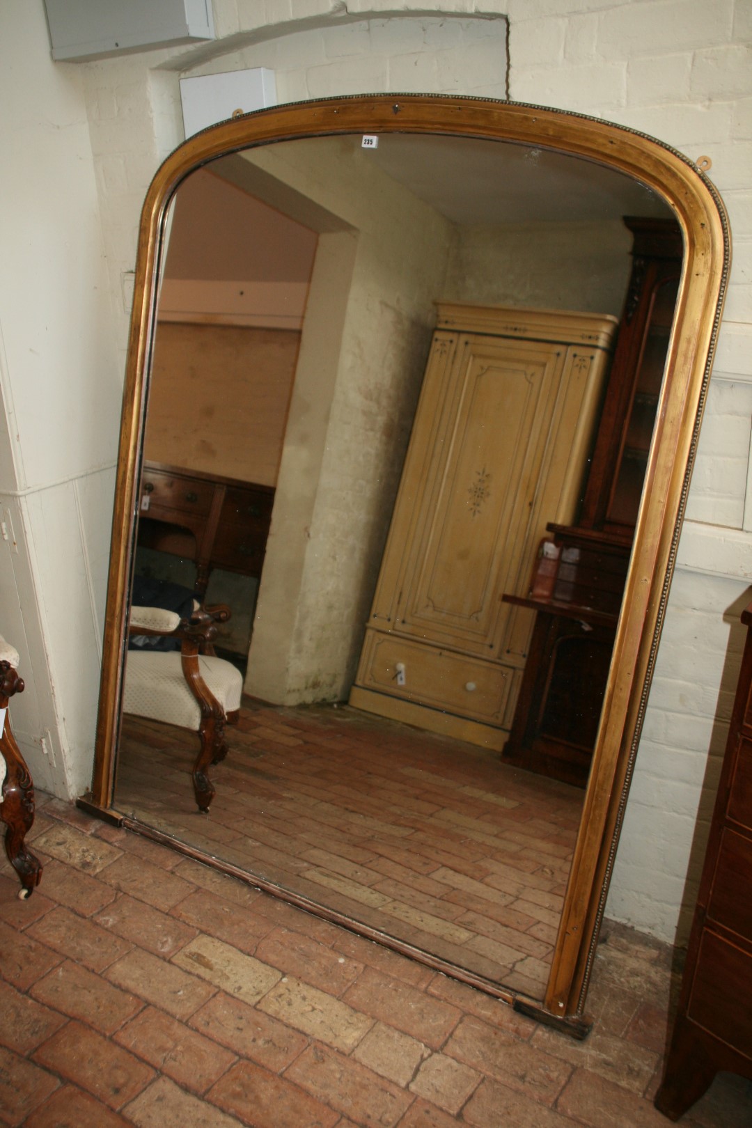 A 19th century gilt framed overmantel mirror of large proportions with beaded border. 56¼ins wide by