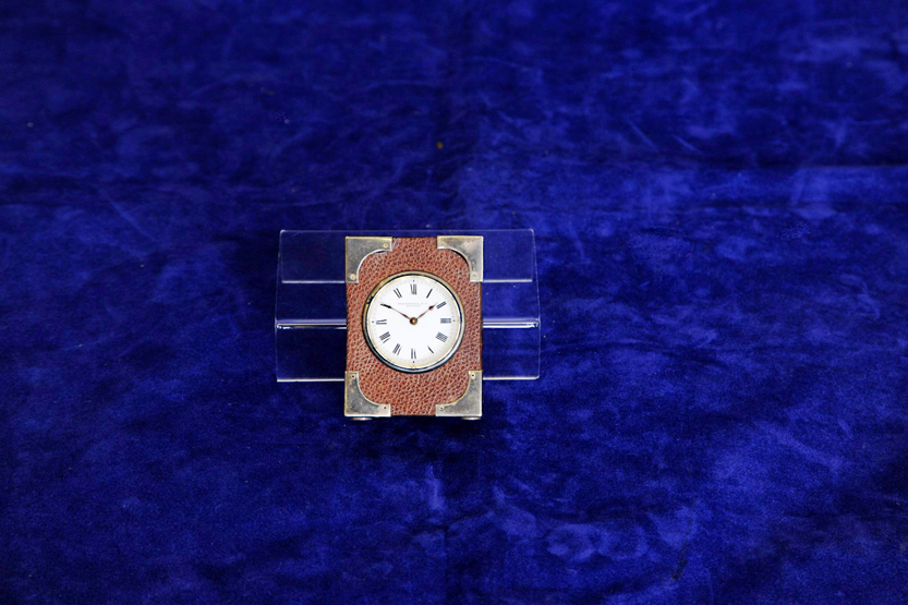 A silver mounted leather cased desk clock, the enamelled dial with Roman numerals and retailers name