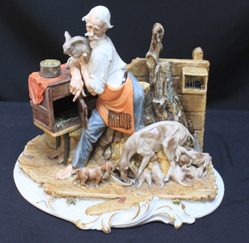 A Capodimonte `style` figure group of an elderly man with a rabbit and hound suckling seven pups,